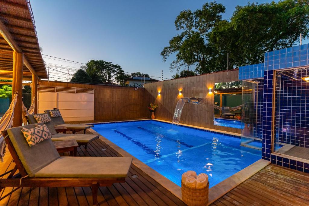 una piscina en un patio trasero con terraza de madera en Kalug - 6 suítes casal, Sauna, Piscina privativa e Área gourmet completa no Centro de Trancoso!, en Trancoso