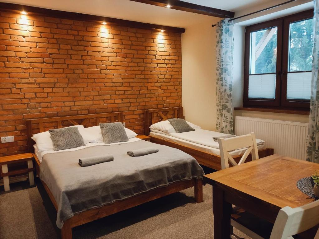 ウストロンにあるBeskidówka z sauną w cenie pobytuのレンガの壁、ベッド2台が備わるベッドルーム1室が備わります。