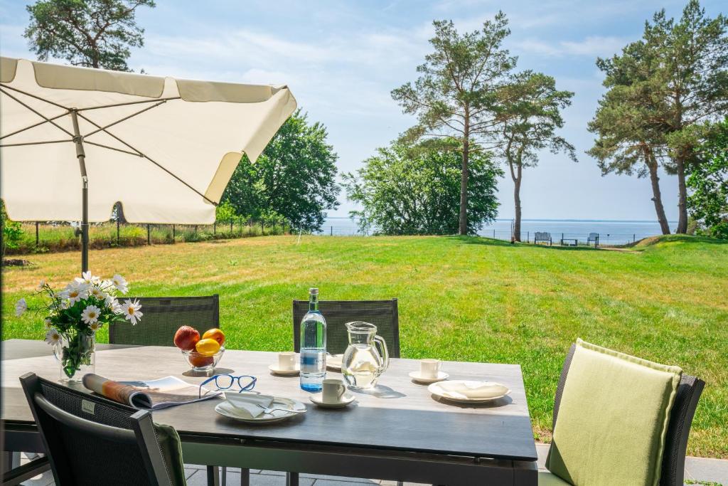 a table with an umbrella and a view of a field at Terrassenwohnung "Inselhain" - Oase am Haff in Garz-Usedom