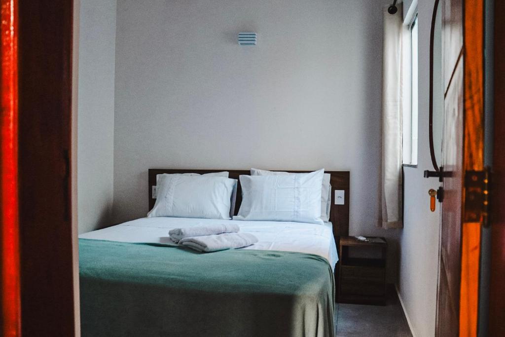 1 dormitorio con 1 cama con 2 toallas en Residencial Ilha do Sol en Arraial d'Ajuda