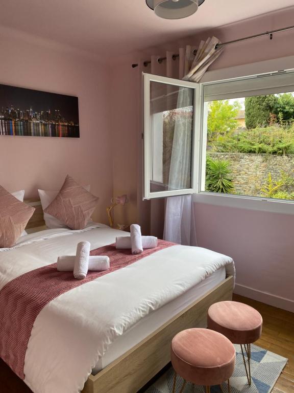 a bedroom with a bed with two stools and a window at Maison face à la cité in Carcassonne