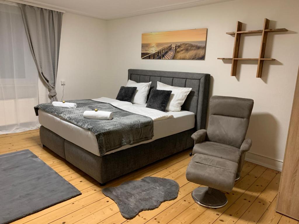 a bedroom with a king sized bed and a chair at BK Apartments in Lörrach