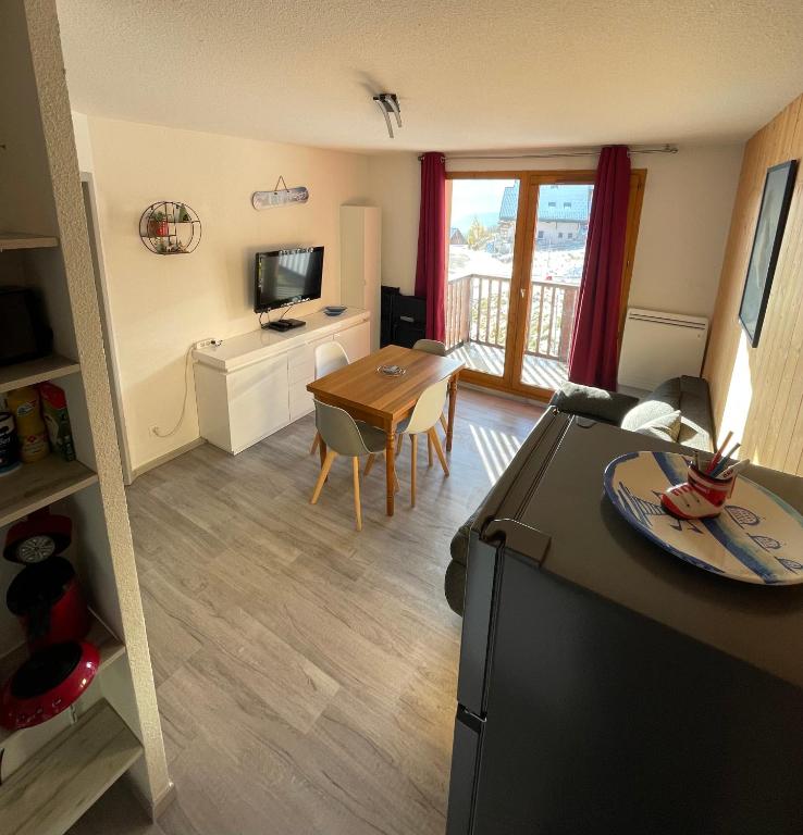 Il comprend une cuisine et un salon avec une table et une télévision. dans l'établissement Appart SFL 1650m, à Saint-François-Longchamp