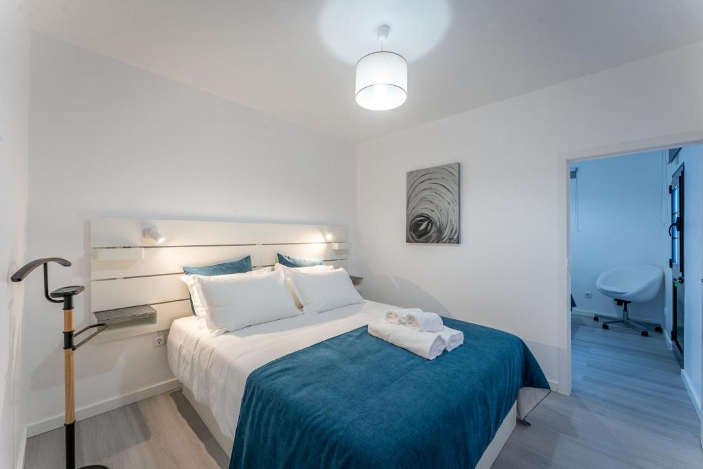 1 dormitorio con 1 cama con manta azul en Fisherman's house, en Porto Moniz