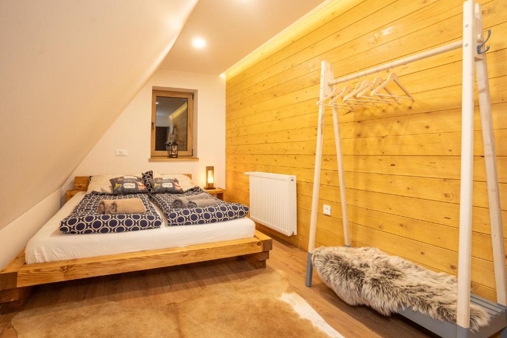 ein Schlafzimmer mit einem Bett und einer Holzwand in der Unterkunft The Magic Forest - Holiday Home & Spa Zone Platak in Soboli