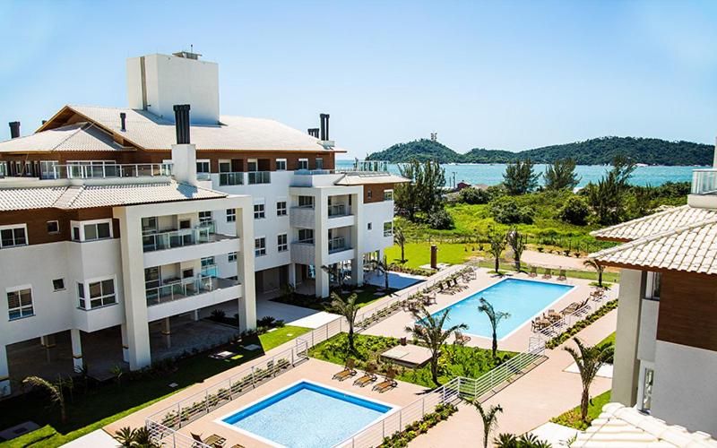 uma vista aérea de um resort com uma piscina em Lindo apartamento frente mar em condomínio club em Florianópolis