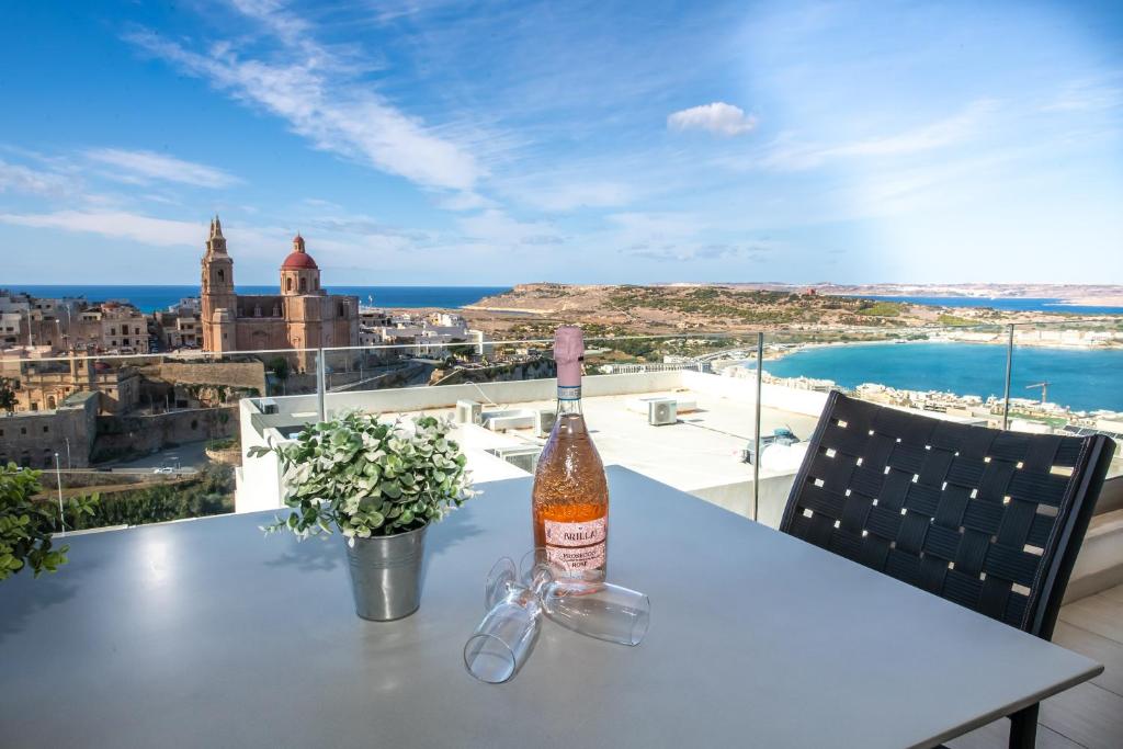 a bottle of wine sitting on a table with a view at Clifftop Modern Apartment in Mellieħa