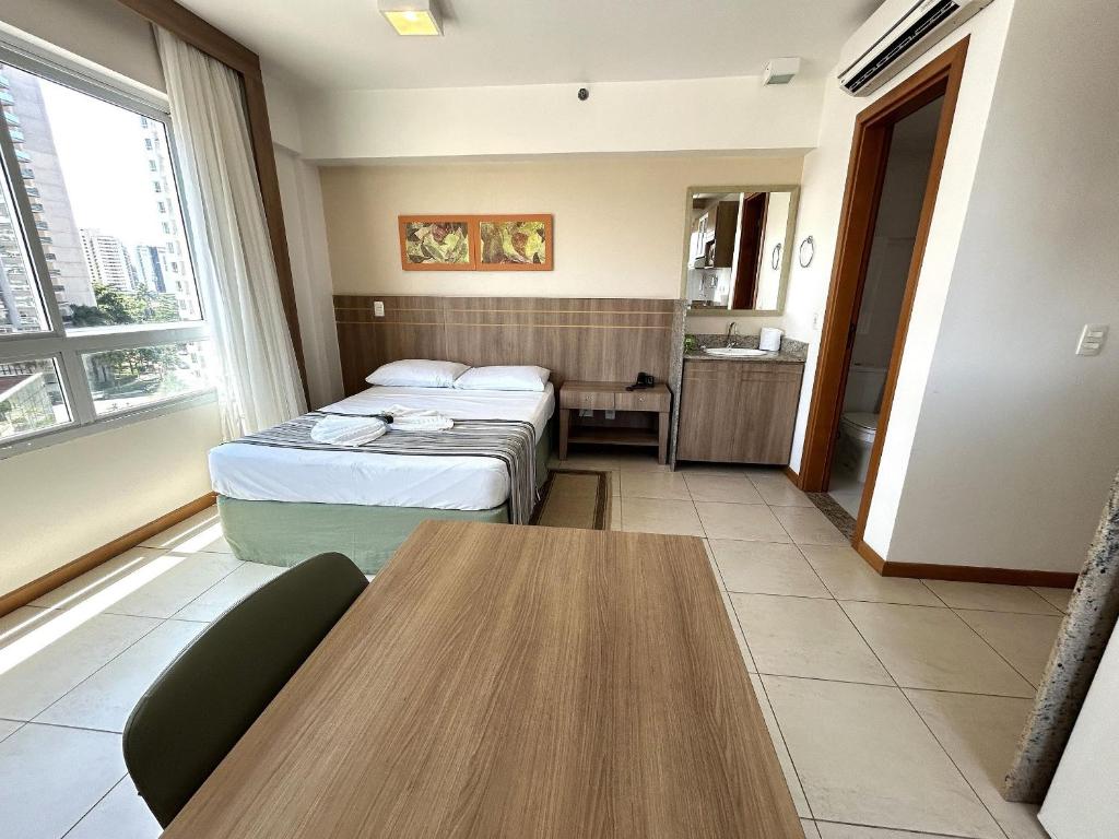 um quarto de hotel com duas camas e uma mesa em SM622 Flat região central Próx Embaixada Americana em Brasília