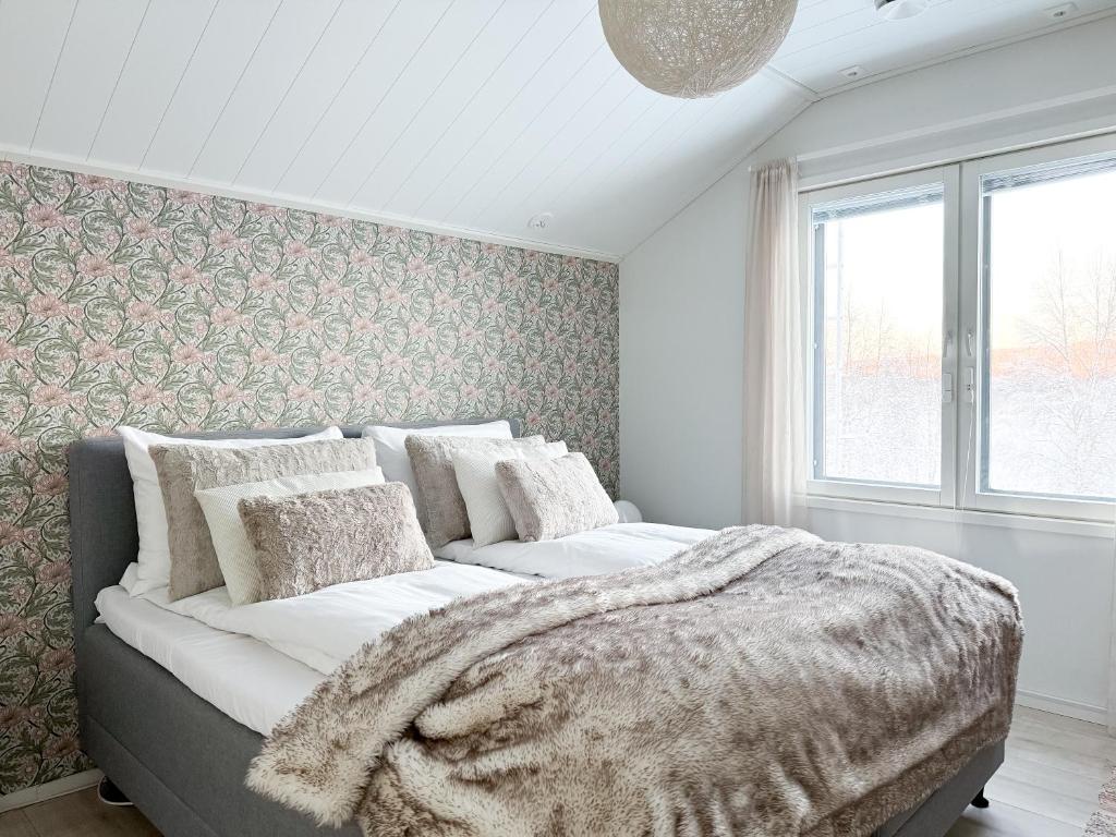 a bedroom with a large bed with a blanket at Villa Arctic Aurora in Rovaniemi