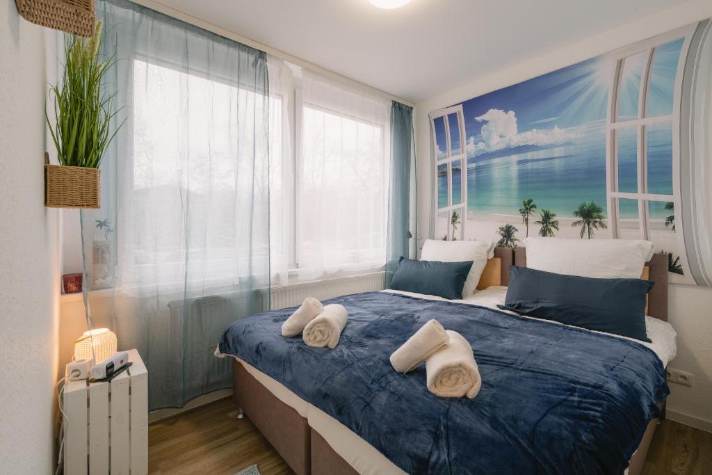 ein Schlafzimmer mit einem blauen Bett und Handtüchern darauf in der Unterkunft Modernes 2-Zimmer Themen-Apartment "Heimathafen" im Zentrum in Bayreuth