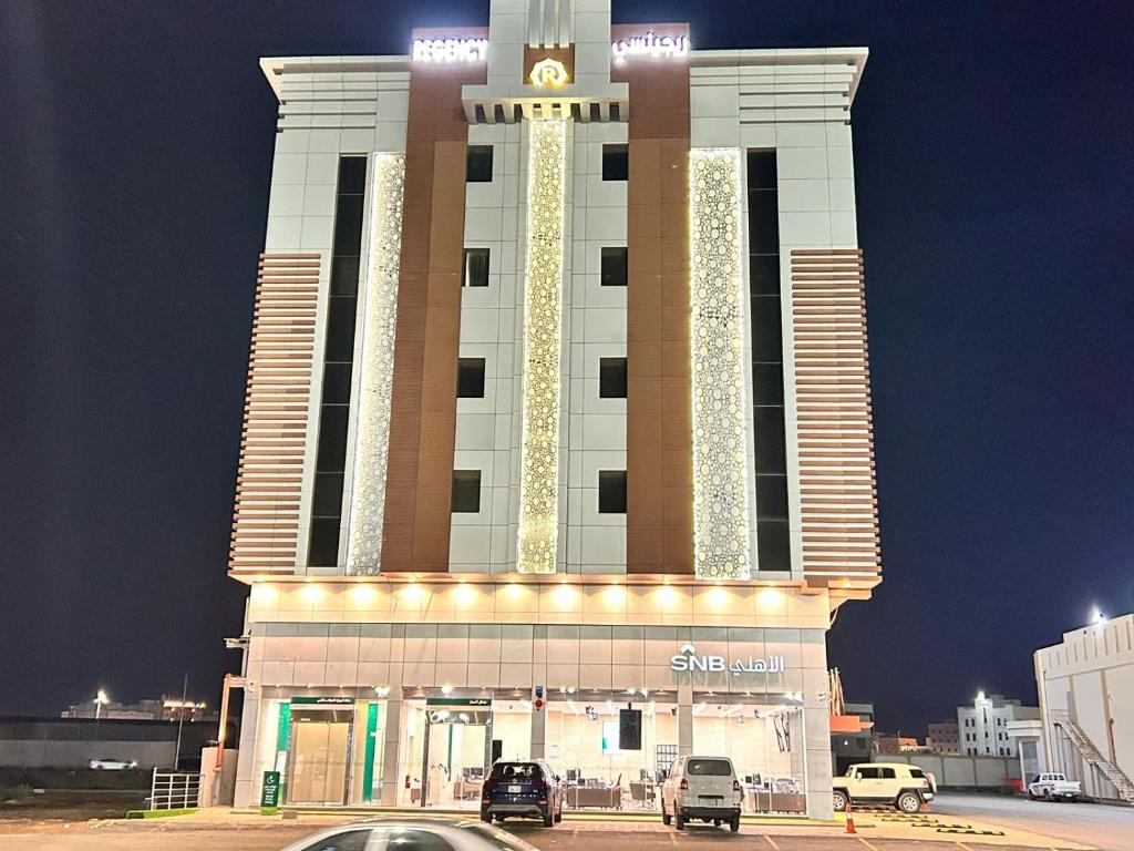 a large building with cars parked in front of it at شقق ريجنسي للشقق المخدومة in Jazan