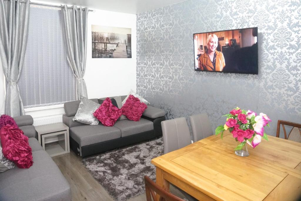 曼徹斯特的住宿－CHEADLE HOUSE HOLIDAYS，客厅配有沙发和桌子
