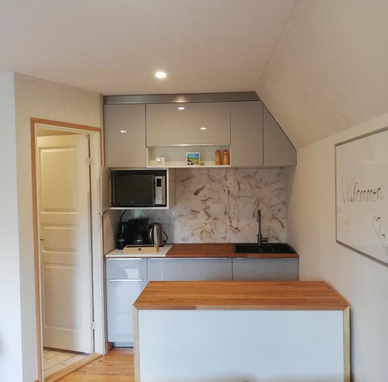 a kitchen with white cabinets and a counter top at Tæt på Langesø in Morud