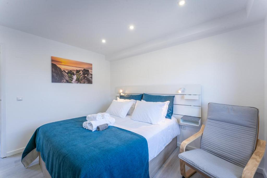 een slaapkamer met een bed en een stoel bij Ocean Breeze in Porto Moniz