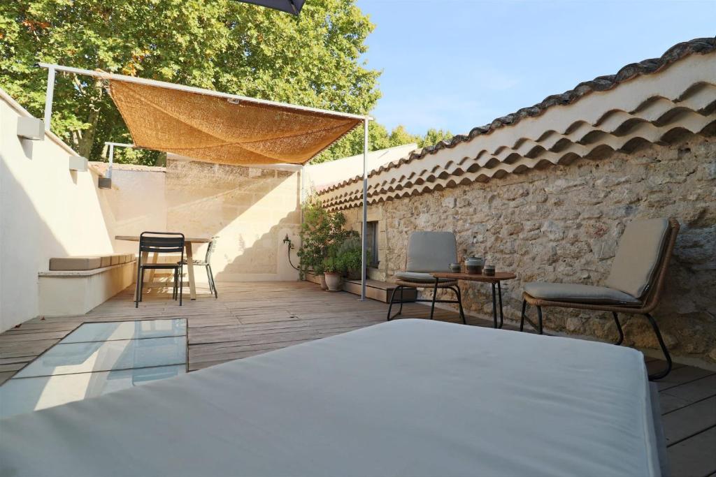 a patio with chairs and a table and a stone wall at Uzès médiévale l&#39;écrin d&#39;Amalia in Uzès