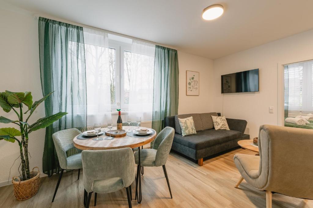 a living room with a table and chairs and a couch at Modernes 2-Zimmer Themen-Apartment "Stadtwäldchen" im Zentrum in Bayreuth