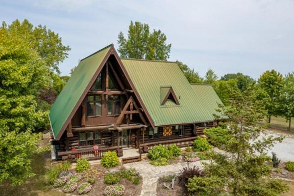 Casa de madera grande con techo verde en The Lodge at Lakeshore, en Belle River