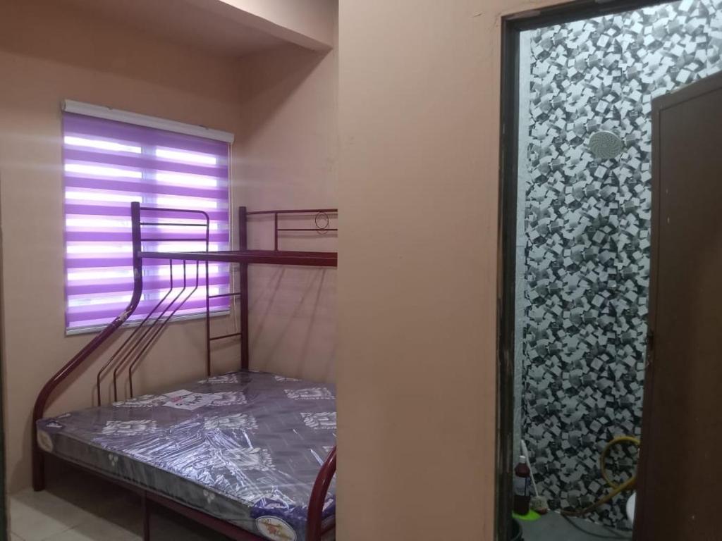 ein kleines Zimmer mit einem Etagenbett und einem Fenster in der Unterkunft Nur Aisyah homestay in Kampong Kemaman