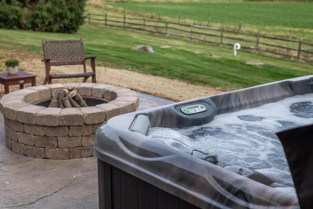 a hot tub with a fire pit in a yard at Arrowhead Cabin/Fields of Home in Millersburg