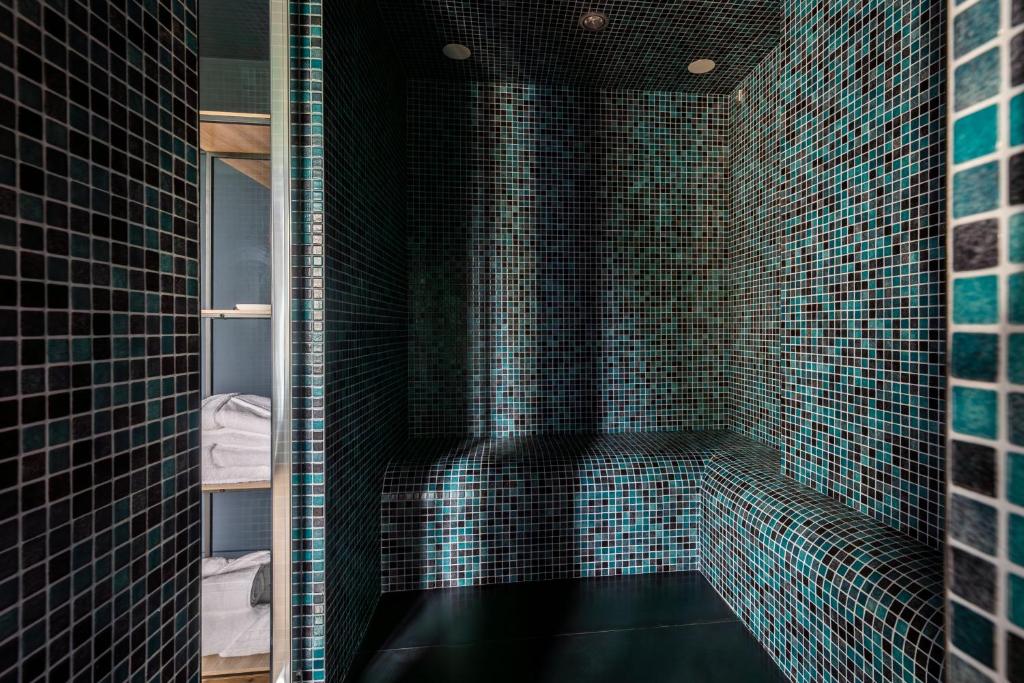 ein Bad mit einer schwarzen Dusche mit blauen Fliesen in der Unterkunft Love room - L'étincelle secrète in Le Ségur-Suech