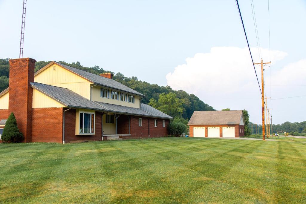 a house with a grass field in front of a house at Dogwood Retreat with big pool! in Warsaw