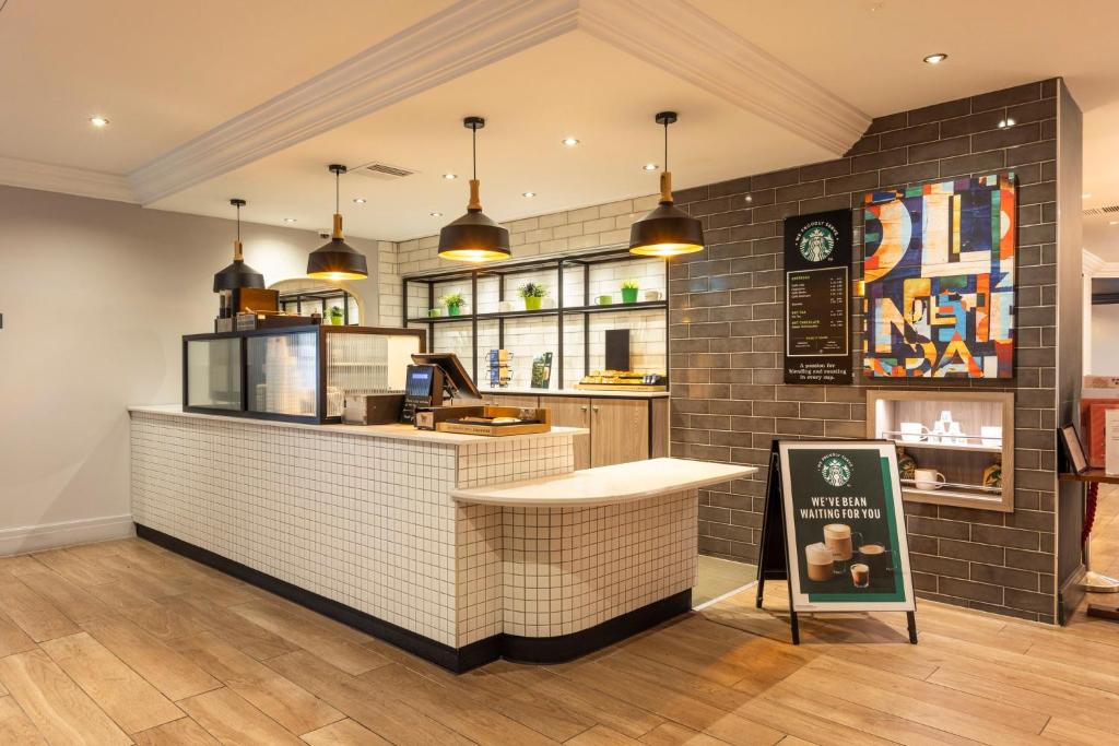 a fast food restaurant with a counter with a sign at Holiday Inn - Glasgow Airport by IHG in Paisley