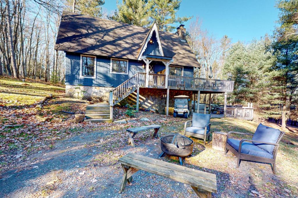 een blauw huis met een terras en meubilair ervoor bij Piney Bear Cabin in Swanton