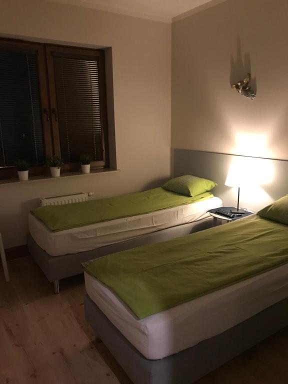 - 2 lits jumeaux dans une chambre avec une lampe dans l'établissement Apartament Józefa, à Toruń