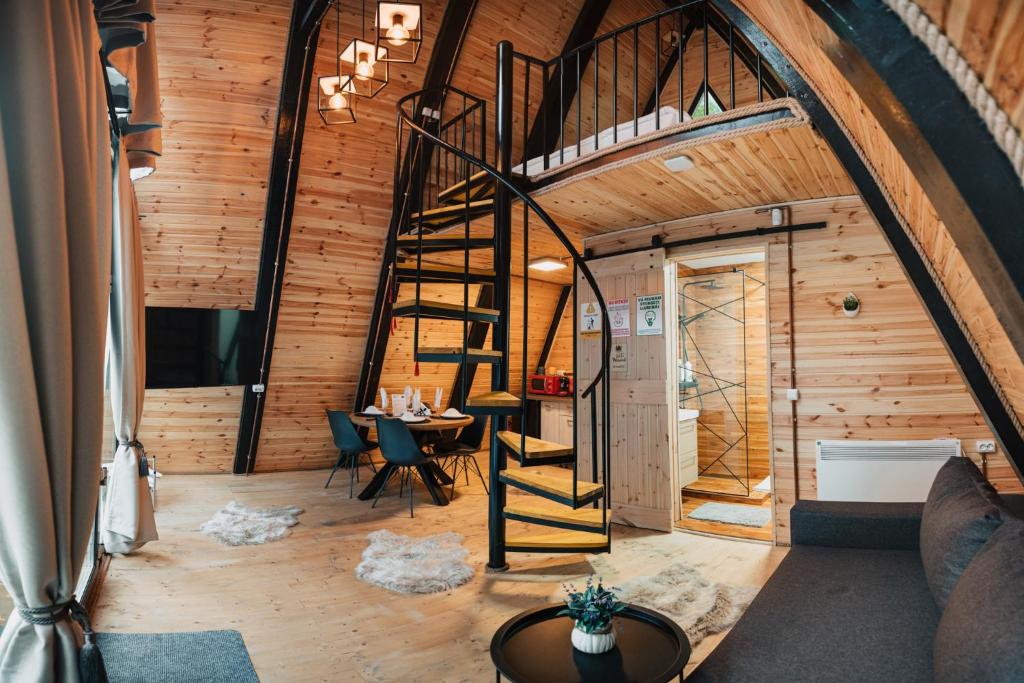 Cette chambre mansardée dispose d'un escalier en colimaçon et d'une table. dans l'établissement Campulung Chalets, à Bughea de Sus