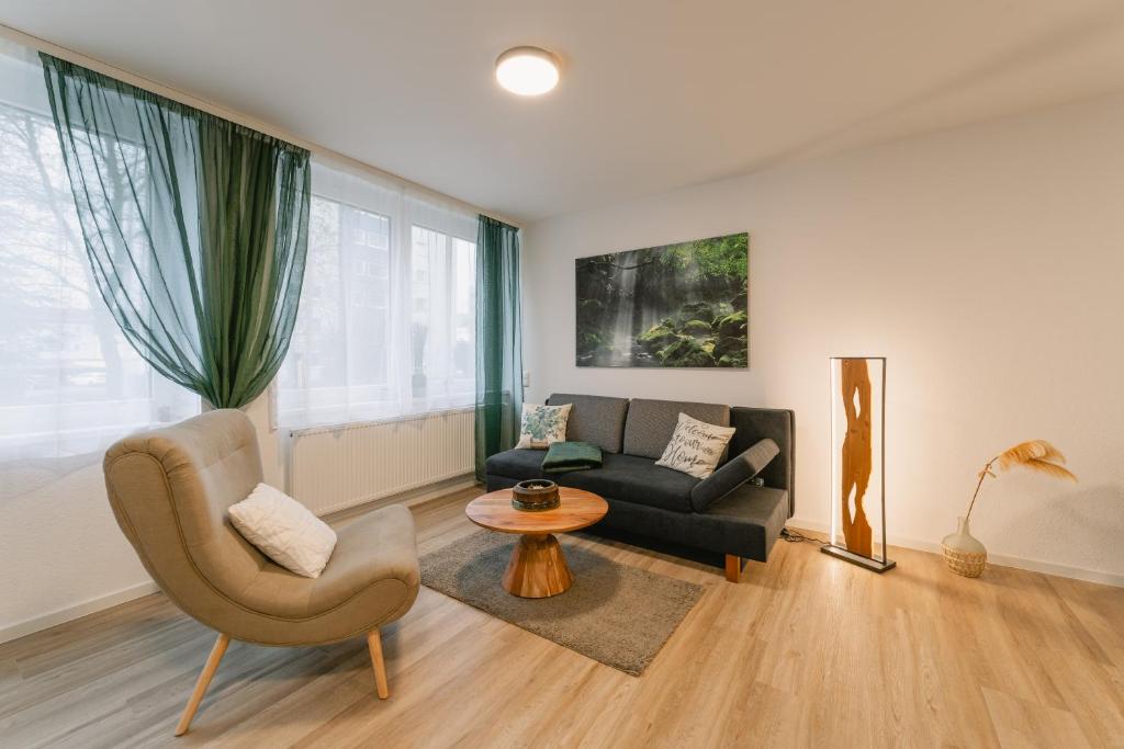 sala de estar con sofá y silla en Modernes 2-Zimmer Themen-Apartment "Frankenwald" im Zentrum, en Bayreuth