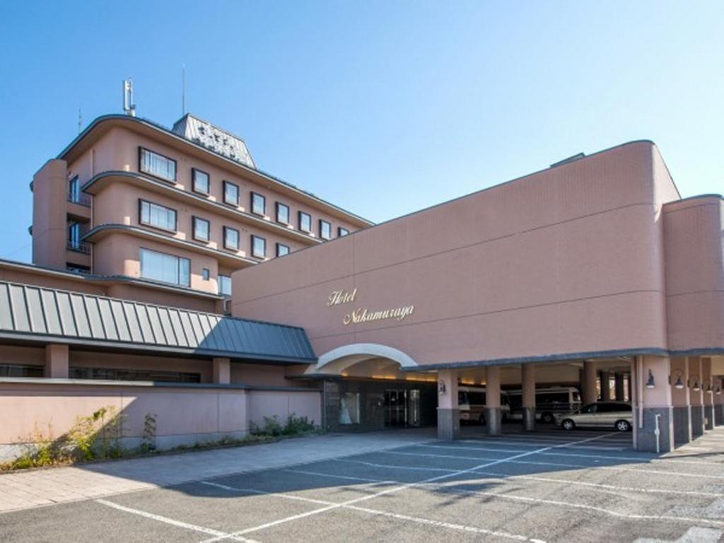 a large building with a parking lot in front of it at Hotel Nakamuraya in Shiojiri