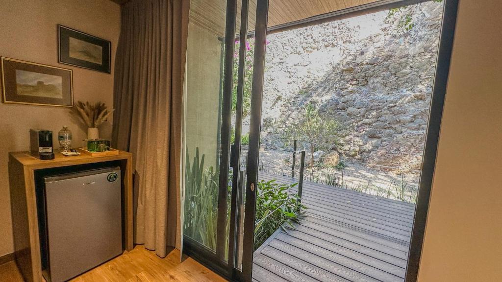 Habitación con puerta corredera de cristal que da a una terraza. en Antigua Guesthaus Suites, en Guanajuato