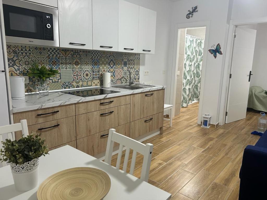 una cocina con armarios blancos y una mesa con sidra de mesa en Welcome to casa Coralia, 