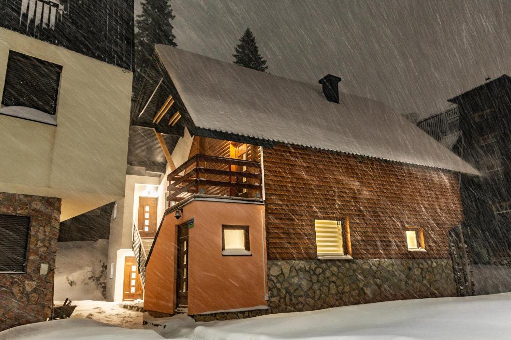 a brick house in the snow with snow falling at Vila "Strahinja" Jahorina in Jahorina