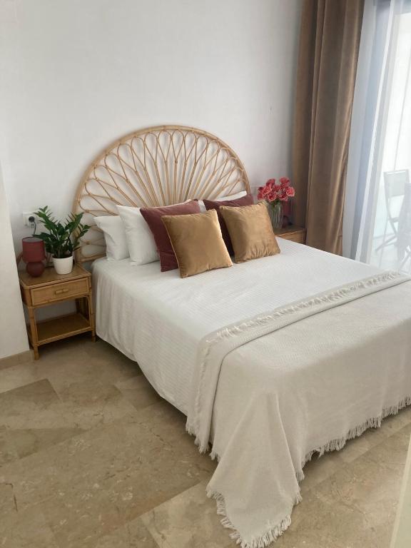 a bedroom with a large white bed with pillows at Balay Apartment Benidorm in Benidorm