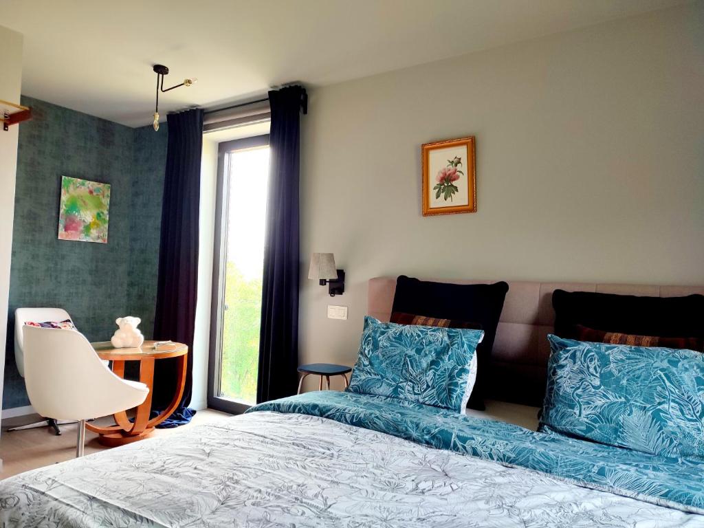 a bedroom with a bed with blue pillows and a window at Housedurbuy in Durbuy