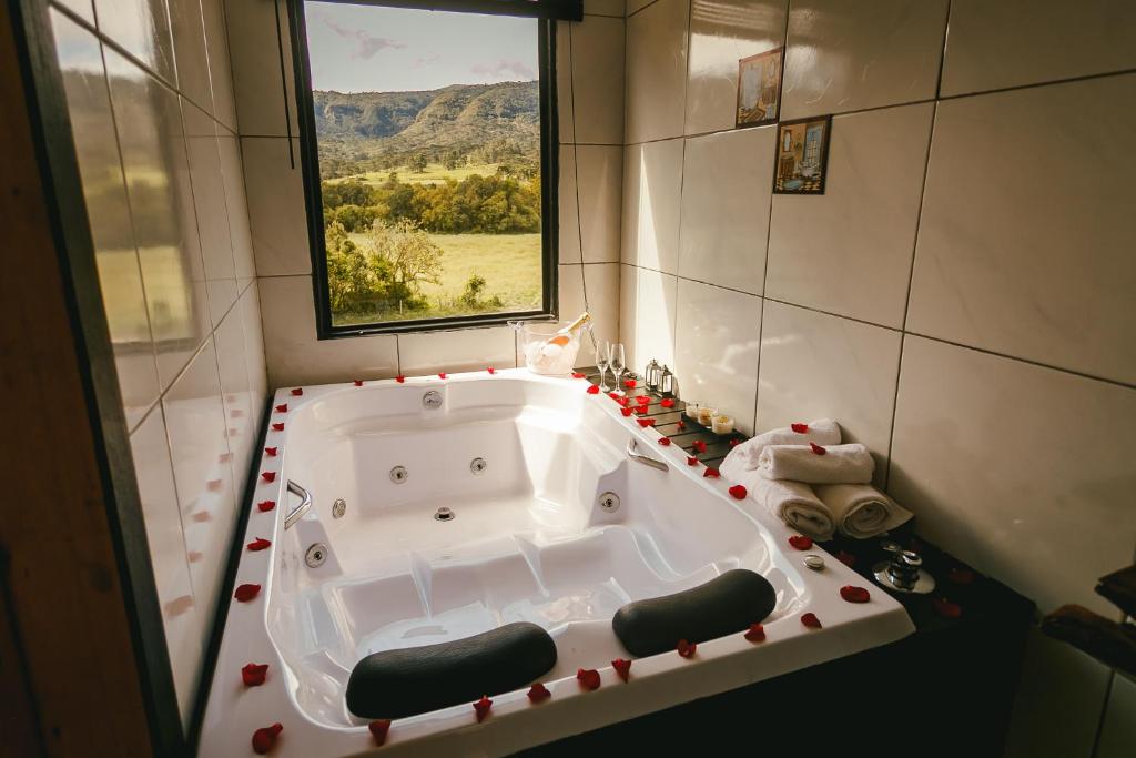 baño con bañera grande y ventana en CHALE SOL NASCENTE en Urubici