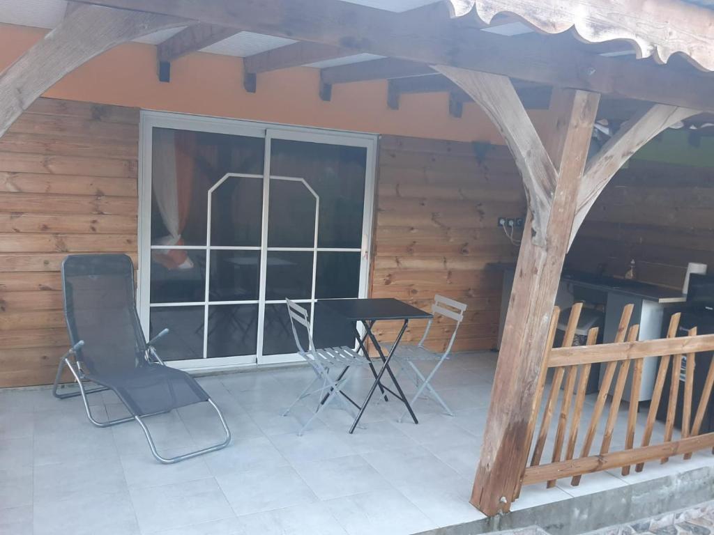 un patio con sillas, una mesa y una ventana en Zabriko delair en Sainte-Anne