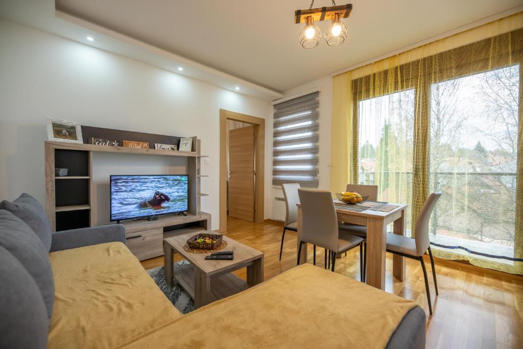 een woonkamer met een bank en een tafel bij Apartmani Oktobar 06 in Zlatibor
