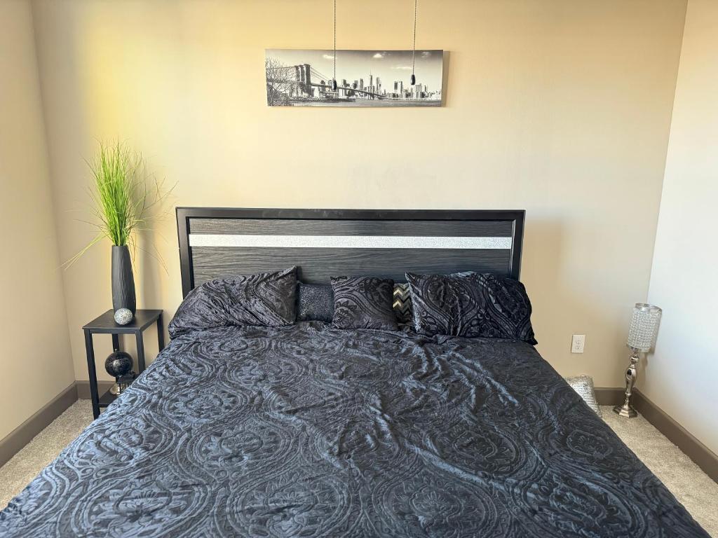 a bedroom with a large bed with a black headboard at Luxury Apartment in Dallas in Addison