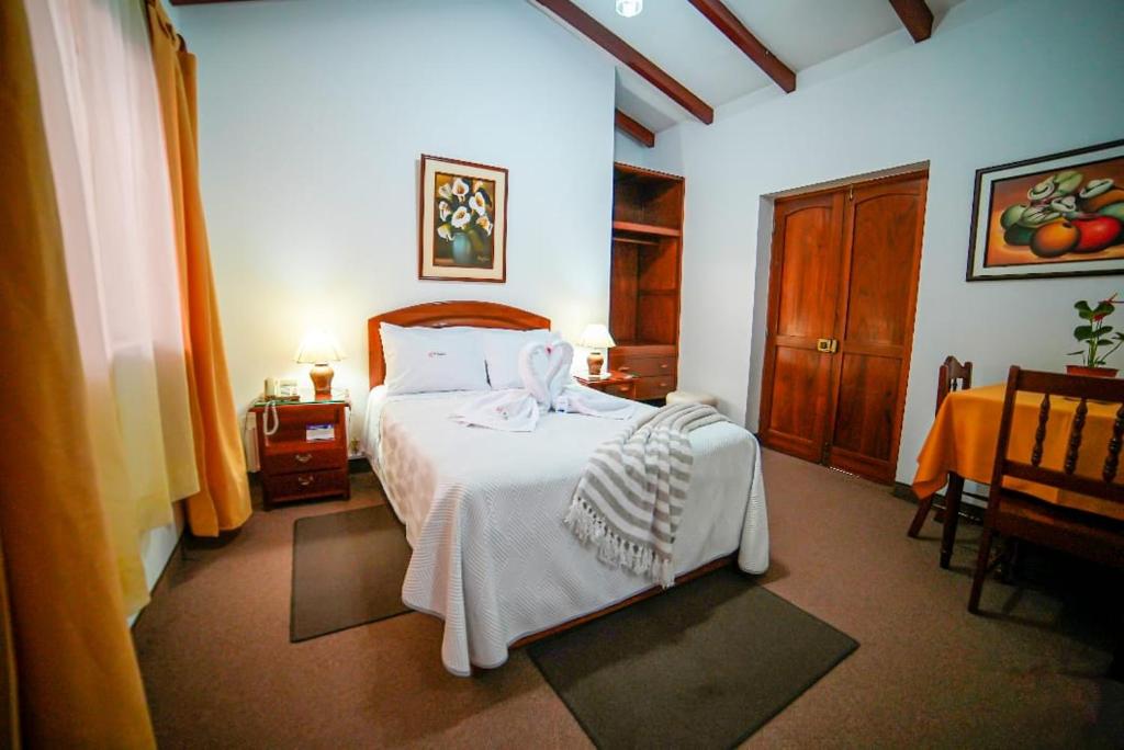 El Cumbe Inn في كاخاماركا: غرفة نوم بسرير ولحاف ابيض