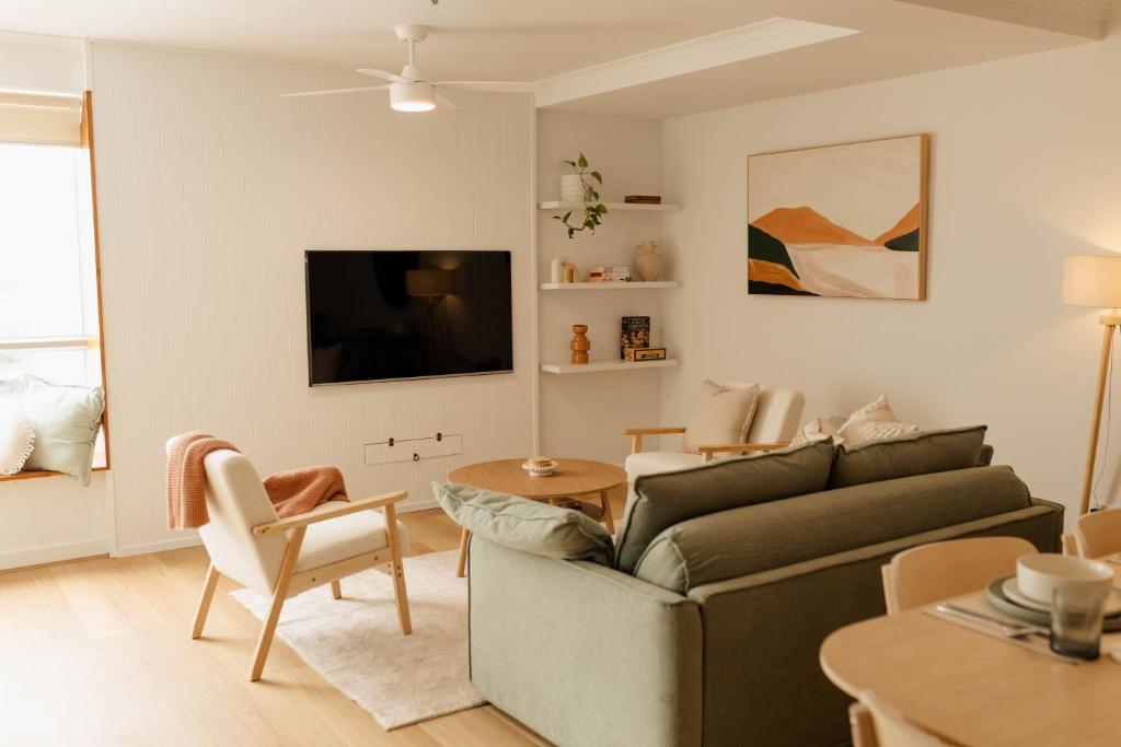 uma sala de estar com um sofá e uma televisão em Vida Central - 2 bed, 1.5 bath w parking, gym & pool em Newcastle