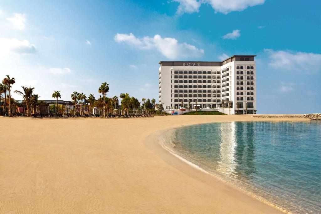 Rove La Mer Beach, Jumeirah في دبي: فندق على الشاطئ بجانب شاطئ رملي