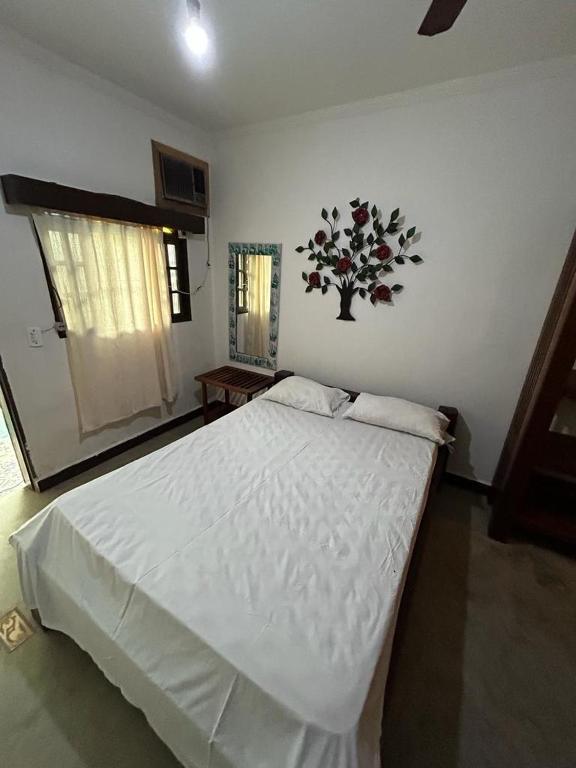 a bedroom with a large white bed in a room at pousada coruja maresias in São Sebastião