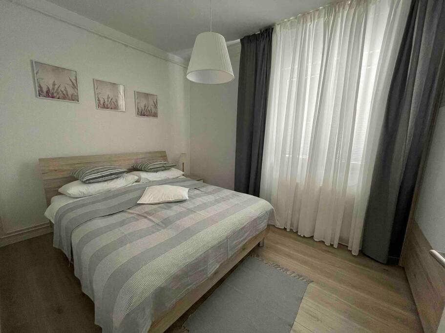 sypialnia z łóżkiem i dużym oknem w obiekcie Apartman III u centru Kutine w mieście Kutina