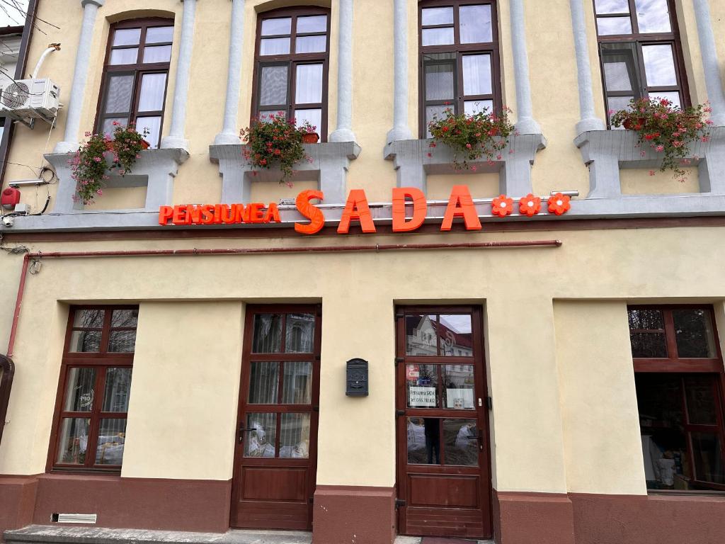 a building with a sign that reads santa saada at Pensiunea SADA in Făgăraş