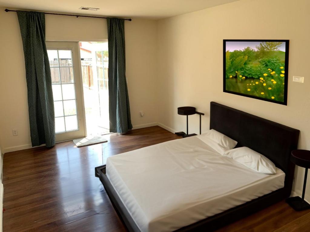 - une chambre avec un lit et une grande fenêtre dans l'établissement West Wing, à San José
