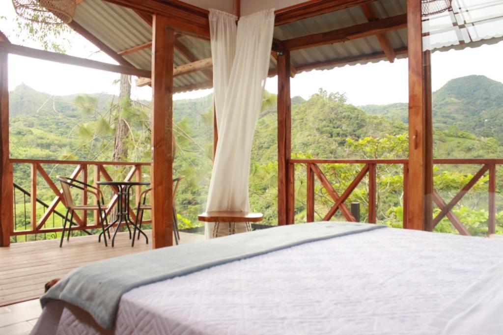 1 dormitorio con cama y vistas a las montañas en cabañas tamborillo, en La Vega