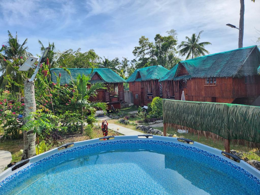 a swimming pool in front of a house at Nirvana Bamboo & Dive resort in Moalboal