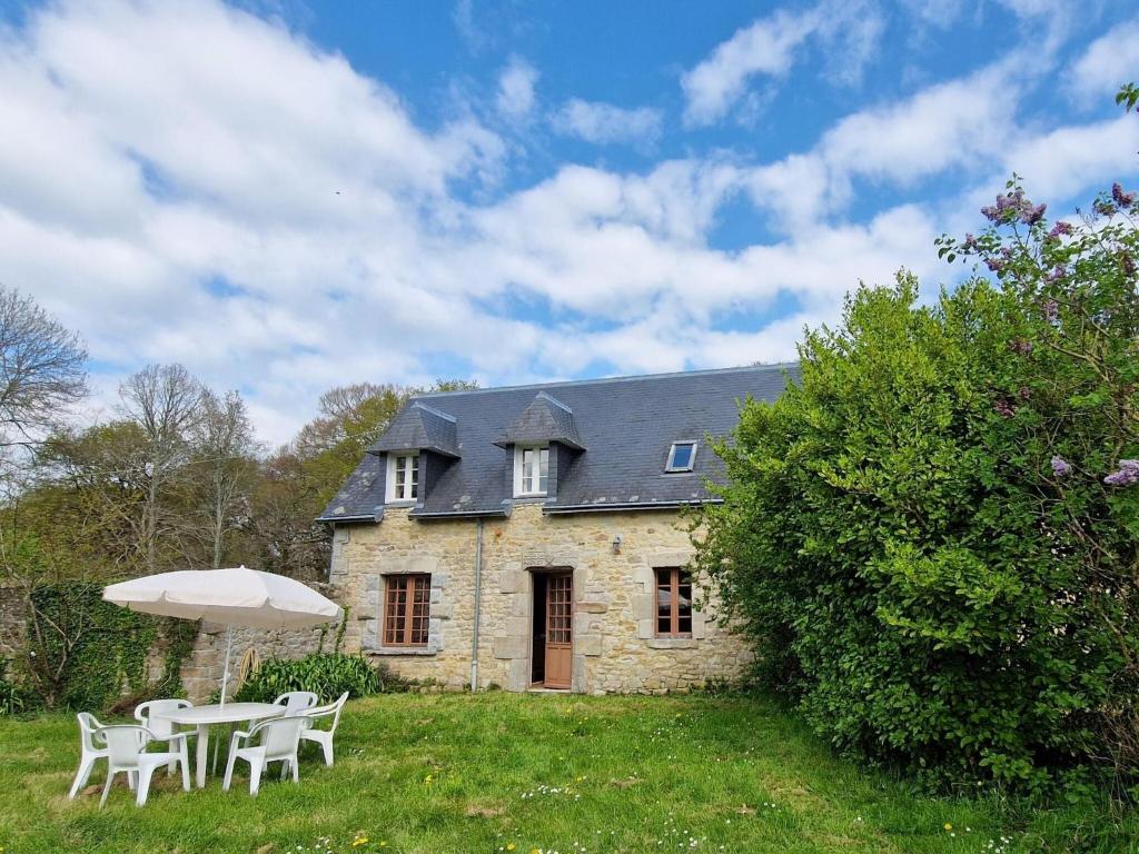 a house with a table and chairs and an umbrella at Apartment in Bénodet near Sandy Beaches in Bénodet